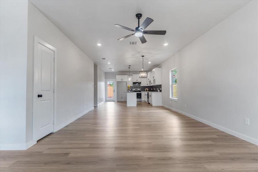 Unfurnished living room featuring light hardwood / wood-style flooring and ceiling fan