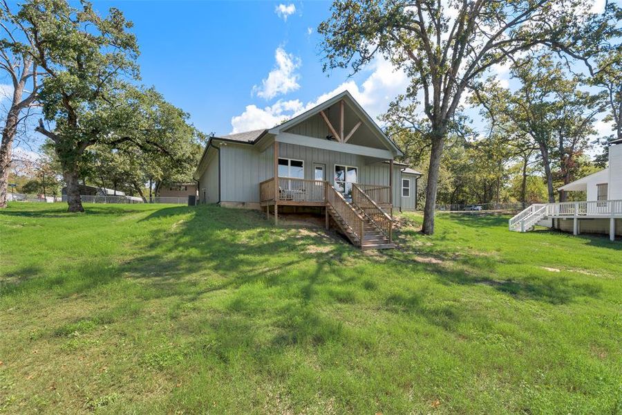 Rear view of house featuring a yard and a deck