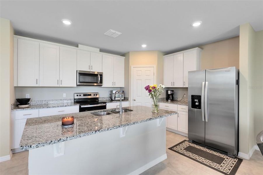 Kitchen features 42" upper cabinets with crown molding, granite countertops and stainless steel appliances