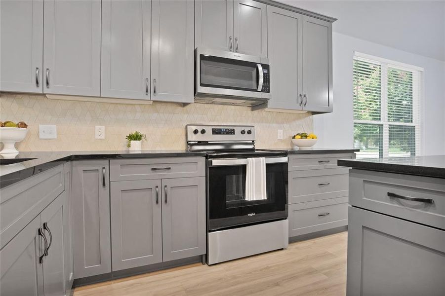 Kitchen featuring built in microwave and electric range.