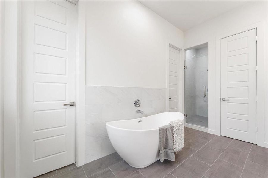 Deluxe Primary Bath, Soaking tub, separate shower with glass door, private enclosed toilet room. His and hers vanities with matching midnight blue soft close cabinets- same as kitchen.