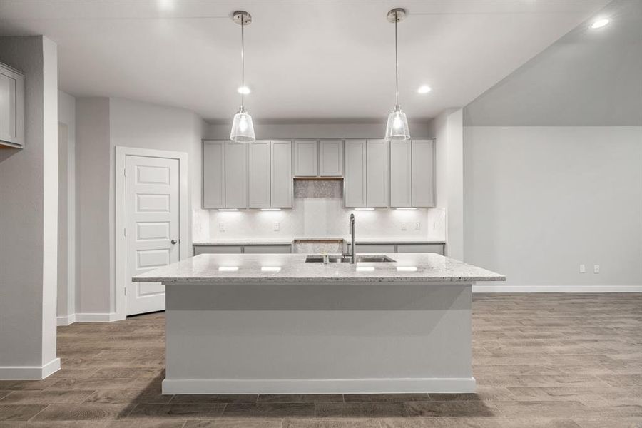 This generously spacious kitchen is a dream realized! Culinary haven, featuring granite countertops, a tile backsplash, stainless steel appliances (to be installed), and 42” upper cabinets. Sample photo of completed home with similar floor plan. As-built interior colors and selections may vary.
