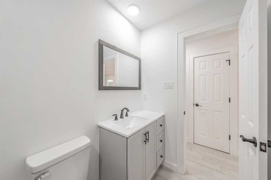 Bathroom featuring hardwood / wood-style floors, vanity, and toilet