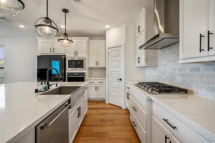 You will love the details of this kitchen! It features crown molding, a large single basin sink with sleek faucet, black cabinet hardware, walk-in pantry, quartz counters, splendid textured backsplash, LED overhead lighting, and SS appliances.