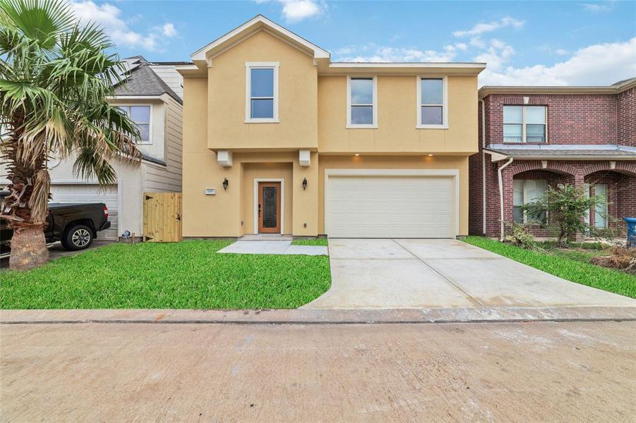 Newly finished, modern two-story home with sleek stucco and durable fiber exterior, complete with a spacious patio for outdoor living.