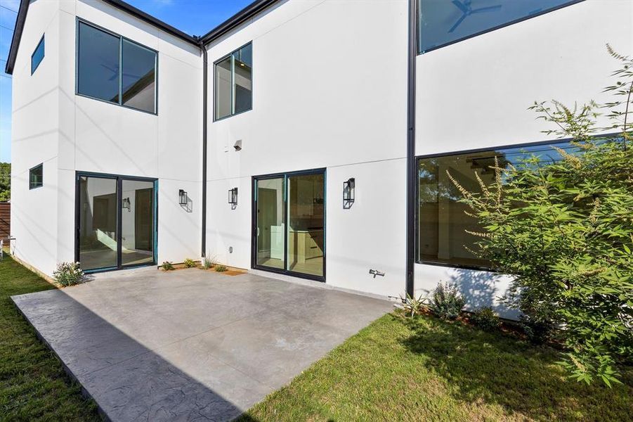 Rear view of property with a yard and a patio