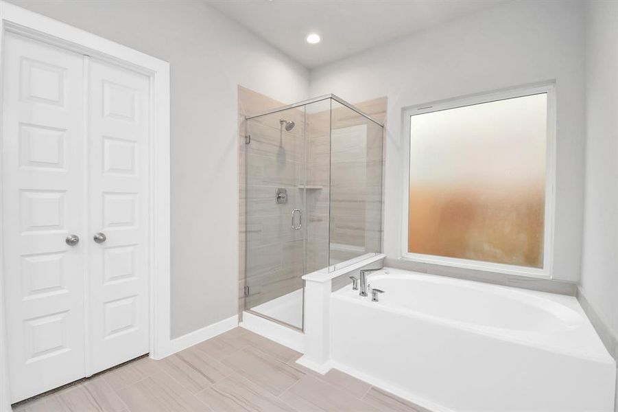 Enjoy the roomy walk-in shower encased in stylish tile, take a moment to unwind in a separate garden tub embellished with custom details. Sample photo of completed home with similar floor plan. Actual colors and selections may vary.