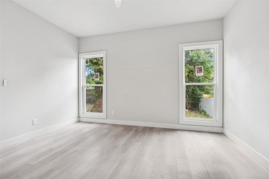 Empty room with light hardwood / wood-style floors and a healthy amount of sunlight