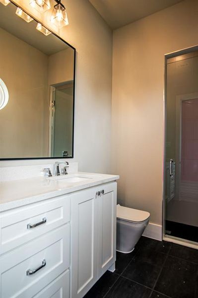 Bathroom featuring tile patterned floors, toilet, and vanity