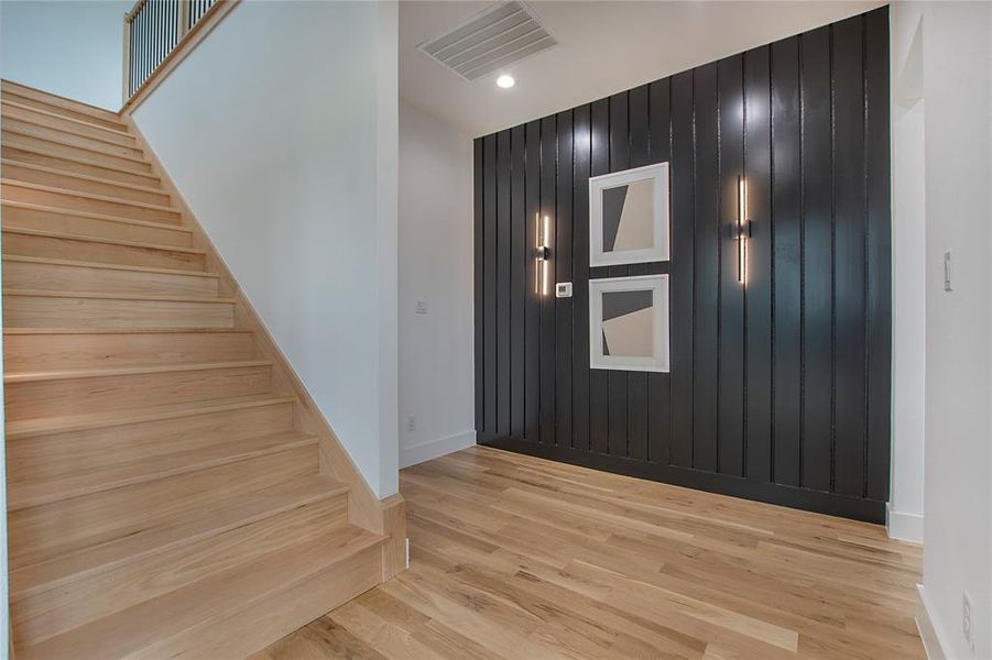 Entryway with light hardwood / wood-style floors and wooden walls