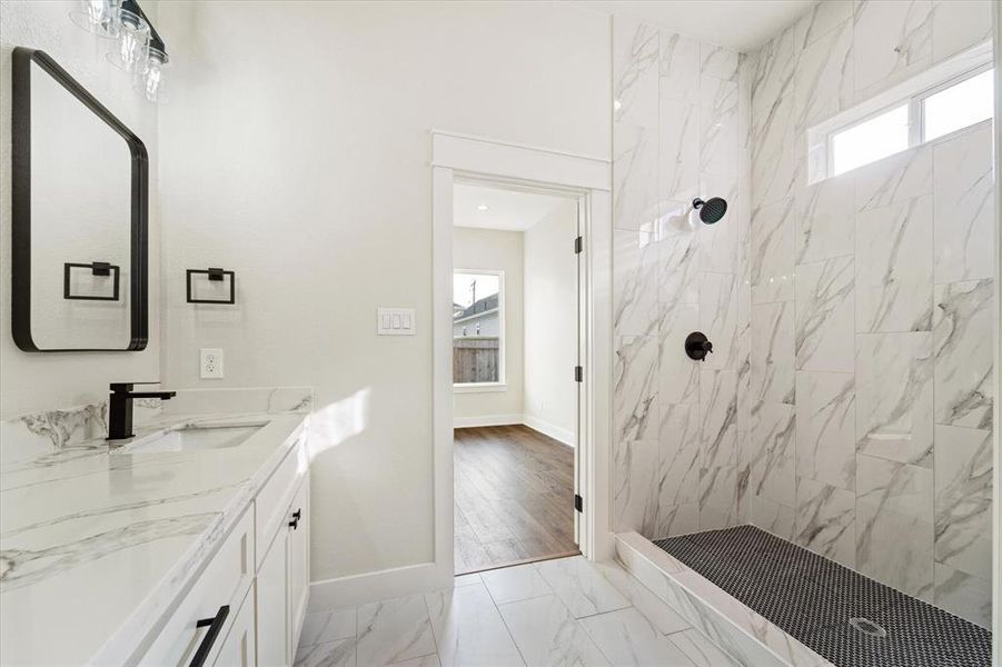 The luxurious walk-in shower is designed with elegant penny tile flooring, a window for natural light, and a convenient soap niche. Plus, a sleek glass door will be added for both style and privacy.