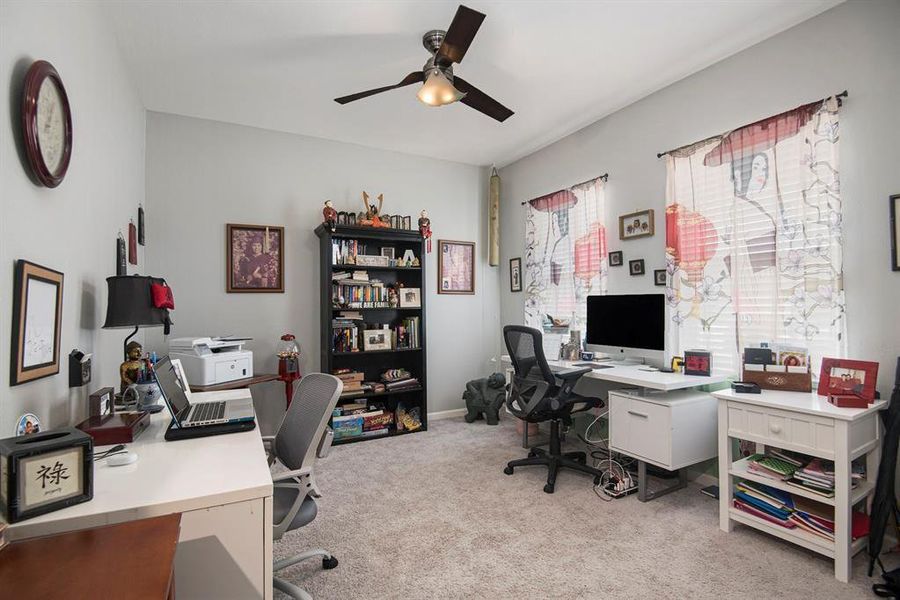 Office space with light colored carpet and ceiling fan