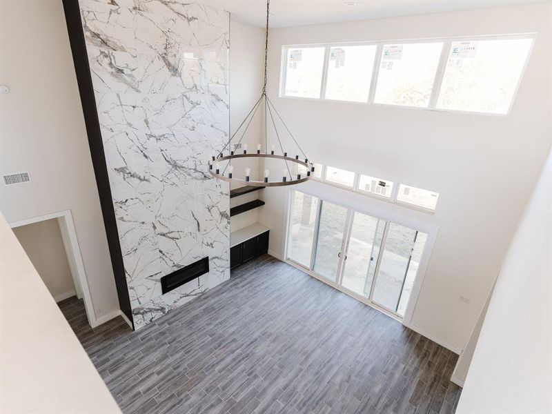 Unfurnished living room with an inviting chandelier and dark hardwood / wood-style floors