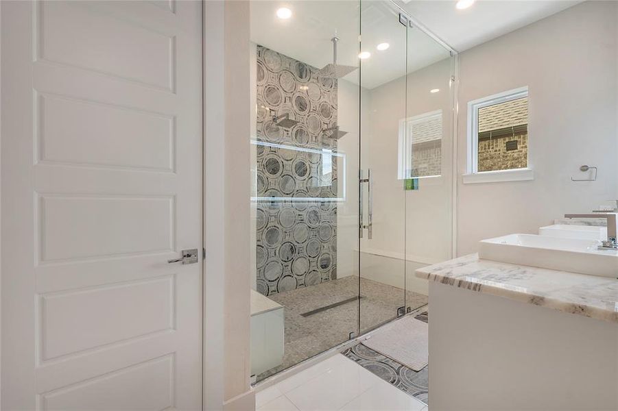 Bathroom featuring tile floors, an enclosed shower, and vanity