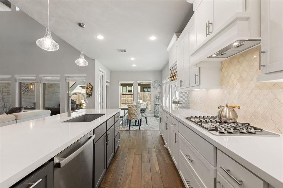 This stunning kitchen displays such a beautiful contrast with the two toned cabinets, neutral paint, Quartz countertops, light modern backsplash, SS appliances, oversized kitchen island with extra storage, breakfast bar, recessed lighting, high ceilings and walk in pantry.