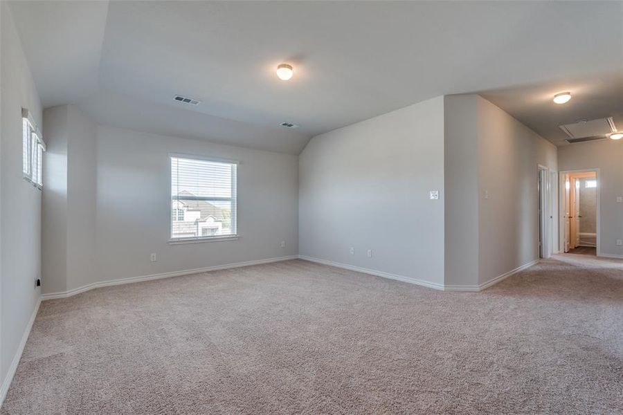 Carpeted spare room with lofted ceiling