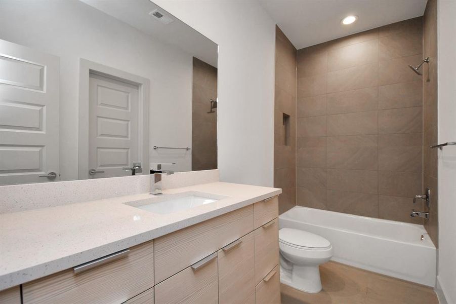 Second full bath with quartz countertops and shower tile to the ceiling