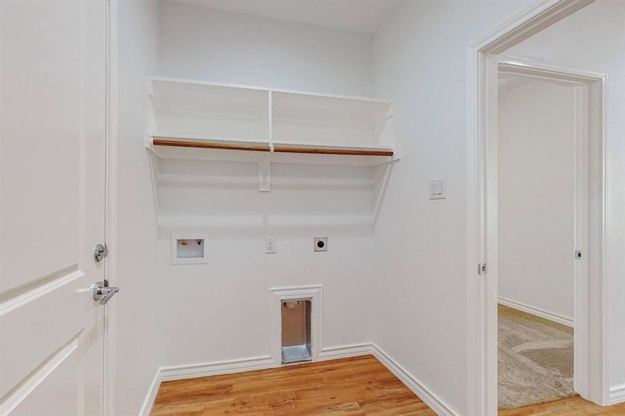 Clothes washing area featuring washer hookup, hookup for an electric dryer, and hardwood / wood-style floors