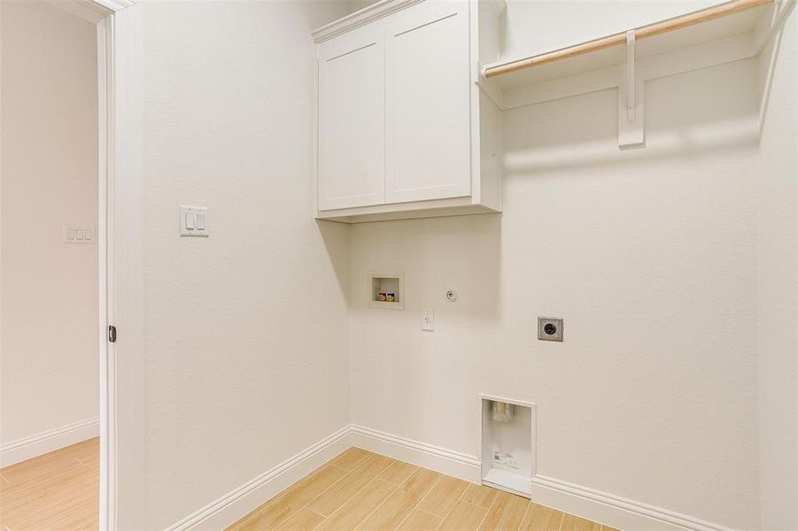 Laundry room featuring washer hookup, gas dryer hookup, light hardwood / wood-style floors, and electric dryer hookup