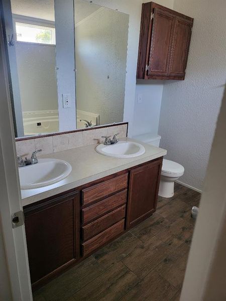 Bathroom featuring hardwood / wood-style floors, toilet, and vanity