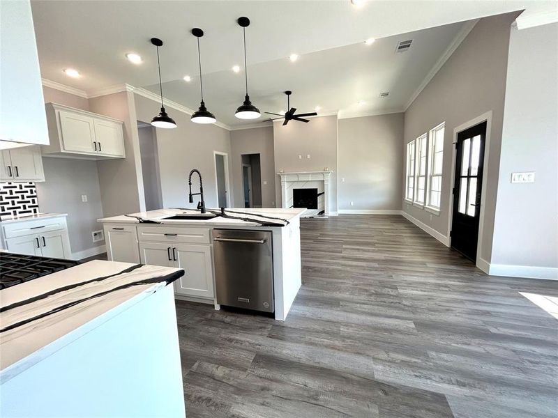 Kitchen with white cabinets, an island with sink, and dark wood-type flooring