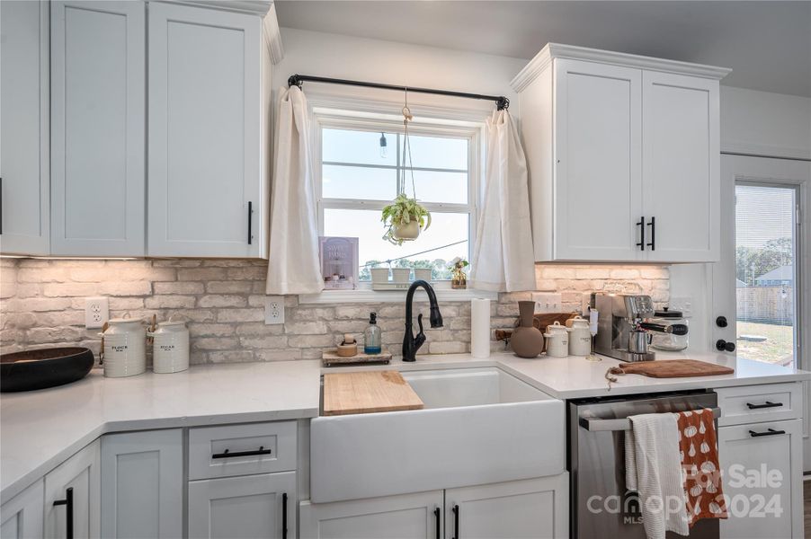 Farmhouse sink, quartz counters and brick back splash