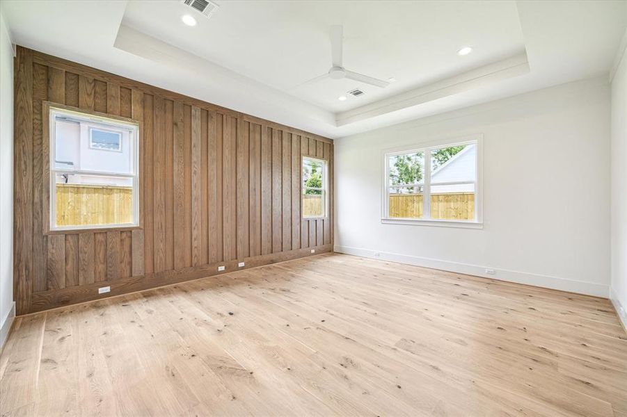 A large primary suite sits downstairs at the back of the home. The french oak flooring runs seamlessly into this space complimenting the wood accent wall.