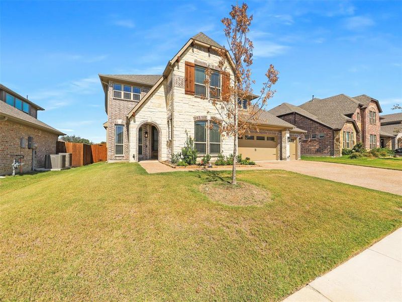 View of front of house with cooling unit, a front lawn, and a garage