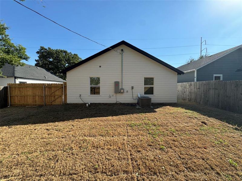 Rear view of property with central AC unit and a yard