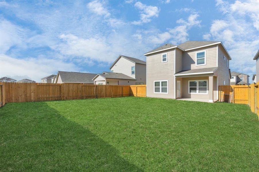 This view of the backyard showcases its impressive size, offering endless possibilities for customization. Whether you dream of adding a garden, play area, or a luxurious outdoor living space, this yard has the potential to become your private oasis. The surrounding fence provides both privacy and security, making it a perfect space for family and pets. **This image is from another Saratoga Home with similar floor plan and finishes, not the June floorplan.**