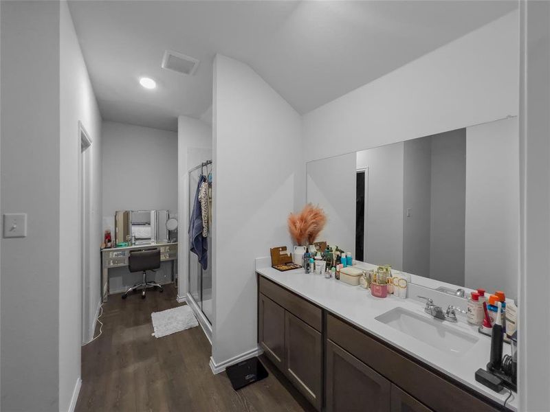 Bathroom with walk in shower, vanity, lofted ceiling, and hardwood / wood-style floors