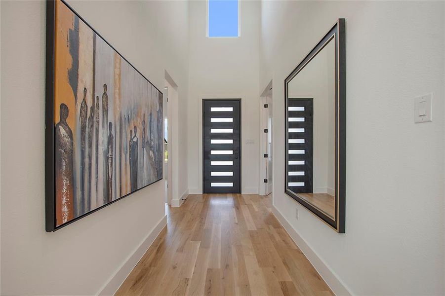 Doorway with a high ceiling and light wood-type flooring