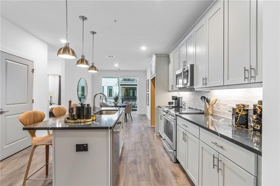 Each kitchen features GE Cafe SS Appliances, Cambria Quartz counters, 42' cabinets and 3 pendant lights above the island. *Model Home-Representative purposes only*