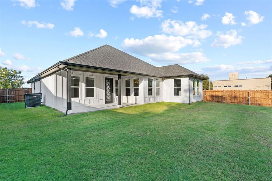 Back of property with a yard, a patio area, and central AC unit