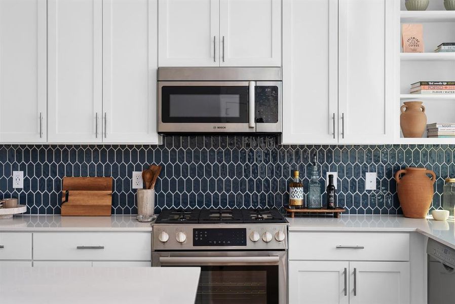 Contemporary kitchen with stainless steel appliances and chic dark backsplash.