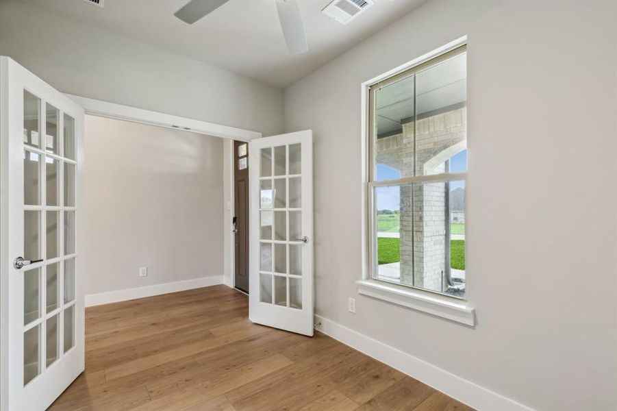 Spare room with french doors, light hardwood / wood-style flooring, and ceiling fan