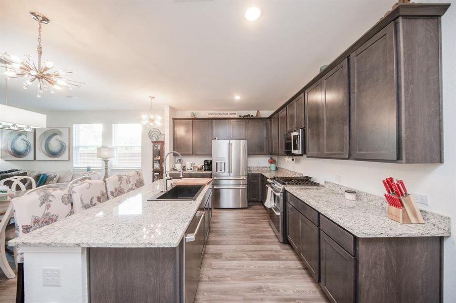 Your new kitchen is simply dreamy!  Granite counters, a new drop-in quartz sink, and all new appliances (builder grade the home came with were good, but these are GE Cafe series & better).  The 42" cabinets offer great storage.  And the eat-in island bar is so convenient!  Notice the new chandeliers as well.