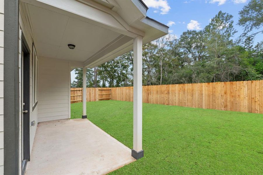 The covered patio is generously sized, providing ample space for various outdoor activities.