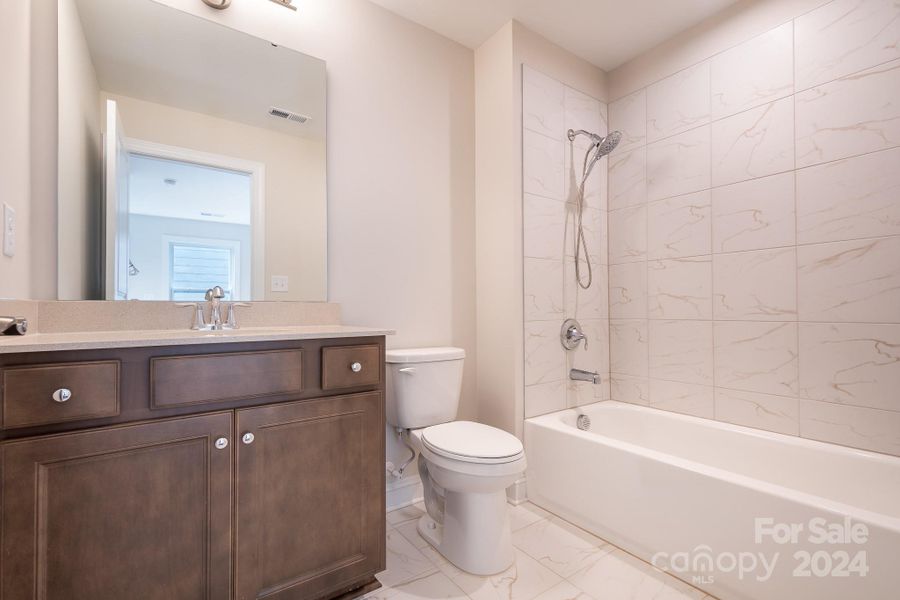 Full Bath in upstairs Loft/Bonus has upgraded cabinetry, gorgeous tile floors and tub with tile surround and upgraded handheld shower.
