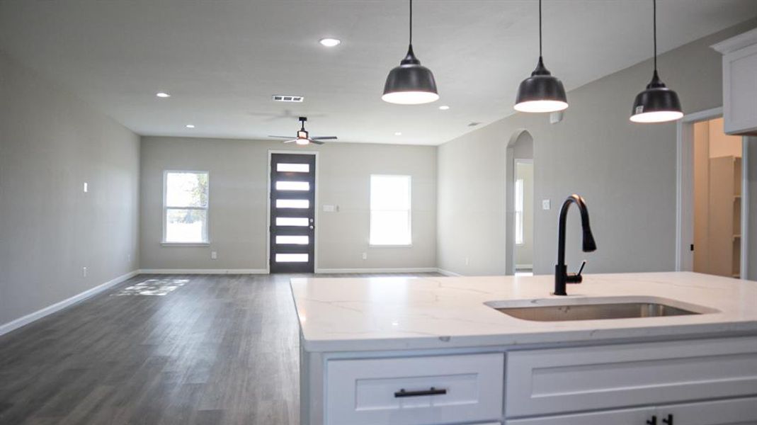 Kitchen featuring a wealth of natural light, sink, and white cabinets