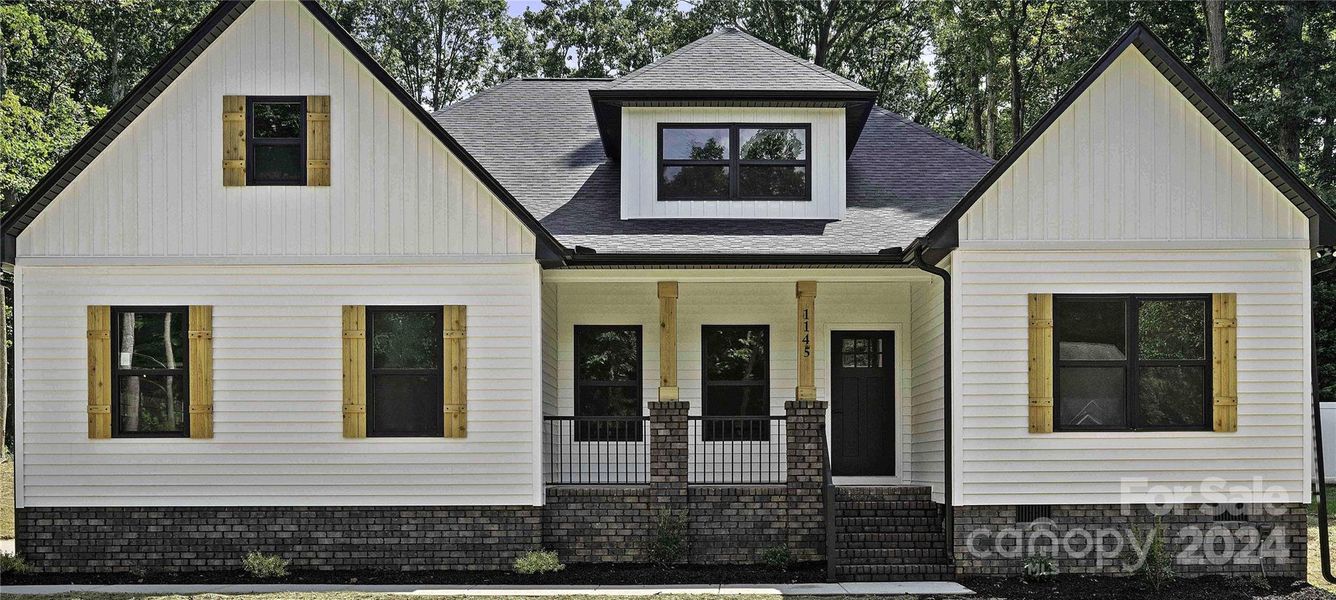 Close view of gorgeous home with black windows & cedar shutters.