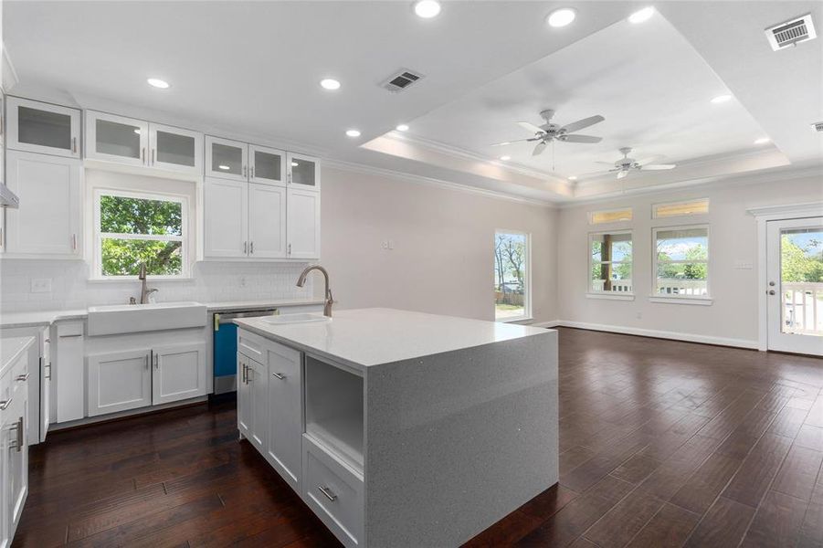 Quartz waterfall island with sink and extra storage space.