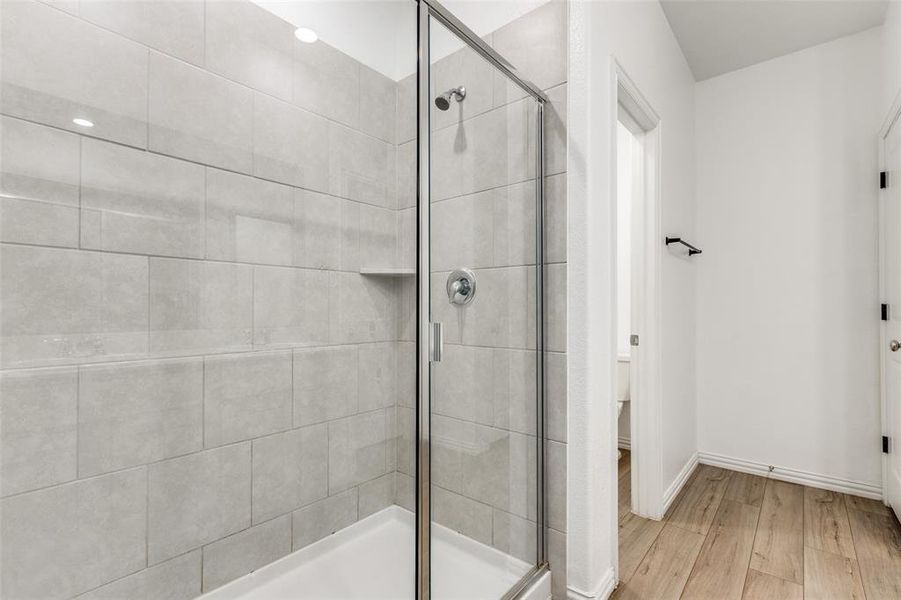 Bathroom with walk in shower and hardwood / wood-style floors