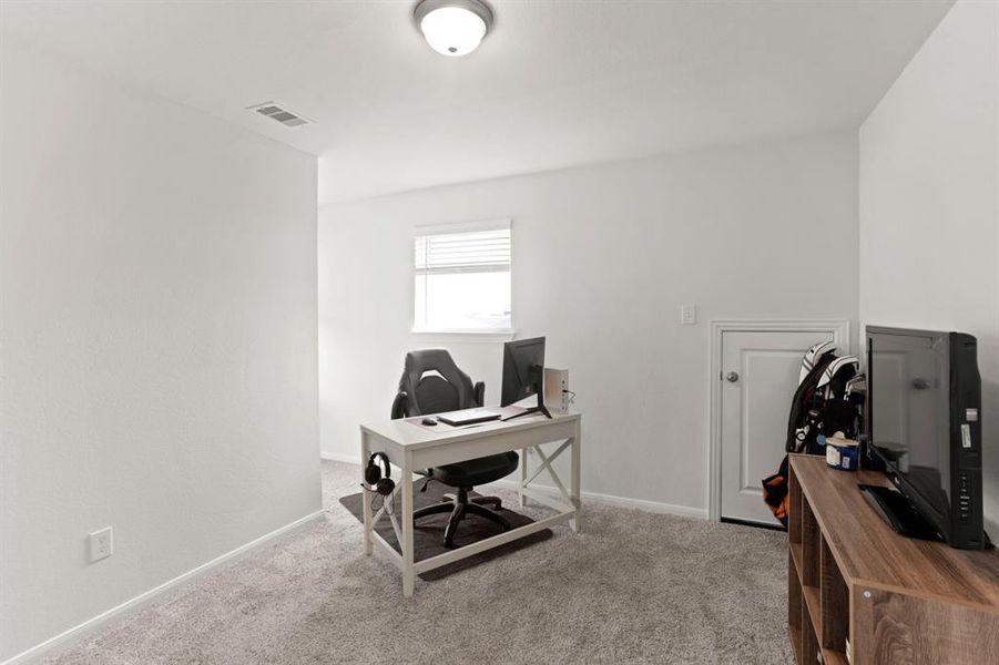 Discover the versatility of this upper-level bedroom, currently fashioned as a home office with a cozy nook perfect for tucking away storage and displaying your favorite reads.