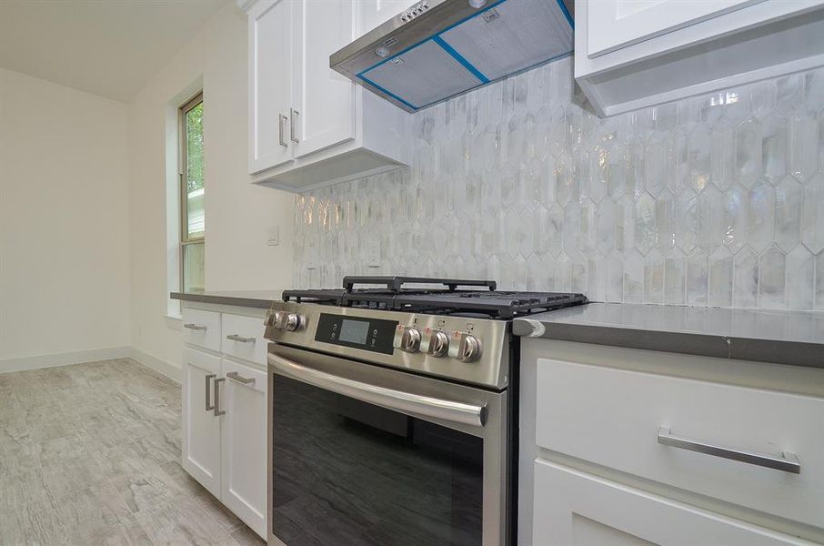 Gas cooktop with vented hood, and single oven. With plenty of built-in custom cabinetry for all your storage needs.