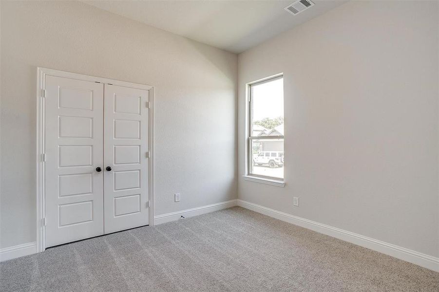 Unfurnished bedroom with light carpet and a closet