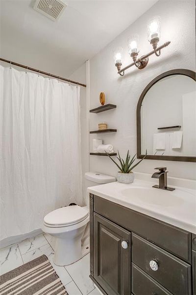 Bathroom featuring vanity, toilet, and a shower with curtain