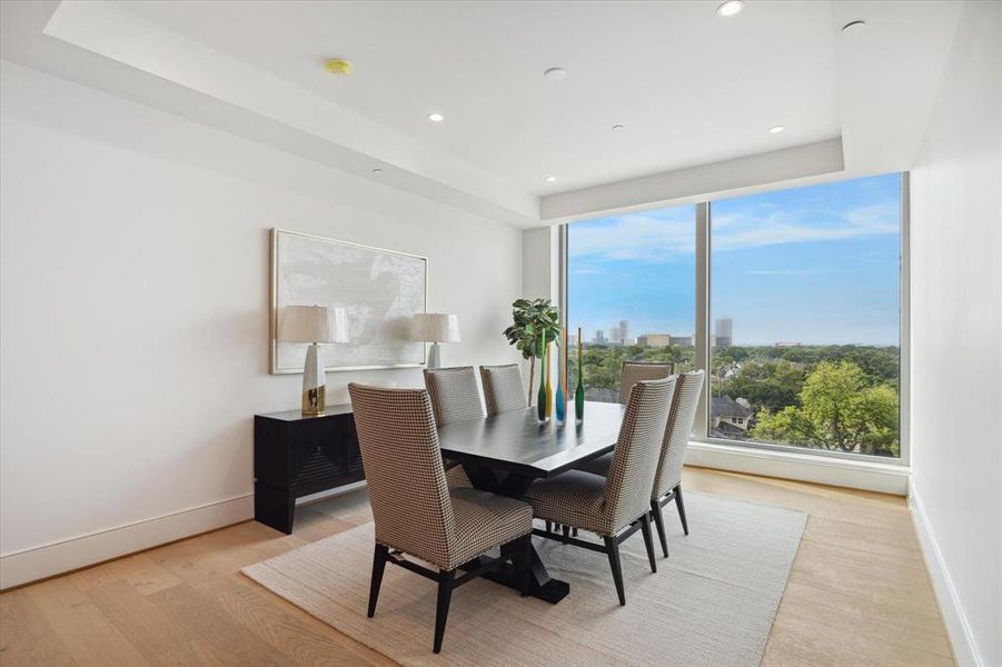 Discover the essence of elegance in the dining area featuring 10-foot-tall ceilings, wide-plank flooring, and floor-to-ceiling double-pane windows capturing southern sunlight and views.