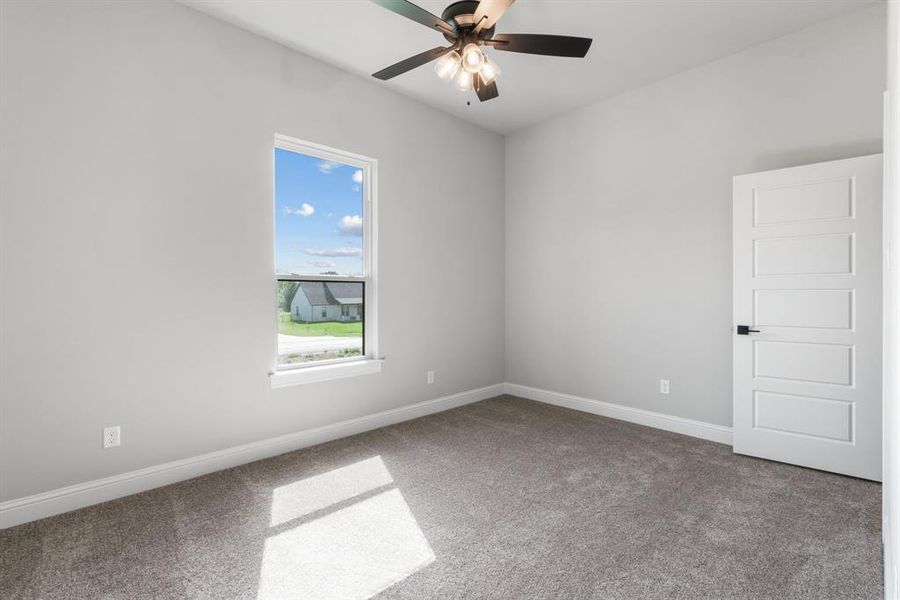 Carpeted spare room with ceiling fan