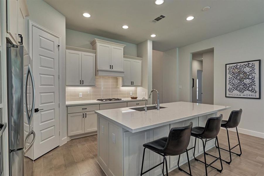 Quartz island with seating options offers plenty of prep space in this chef's kitchen!  Under-cabinet lighting is a plus and kitchen is pre-wired for pendants.